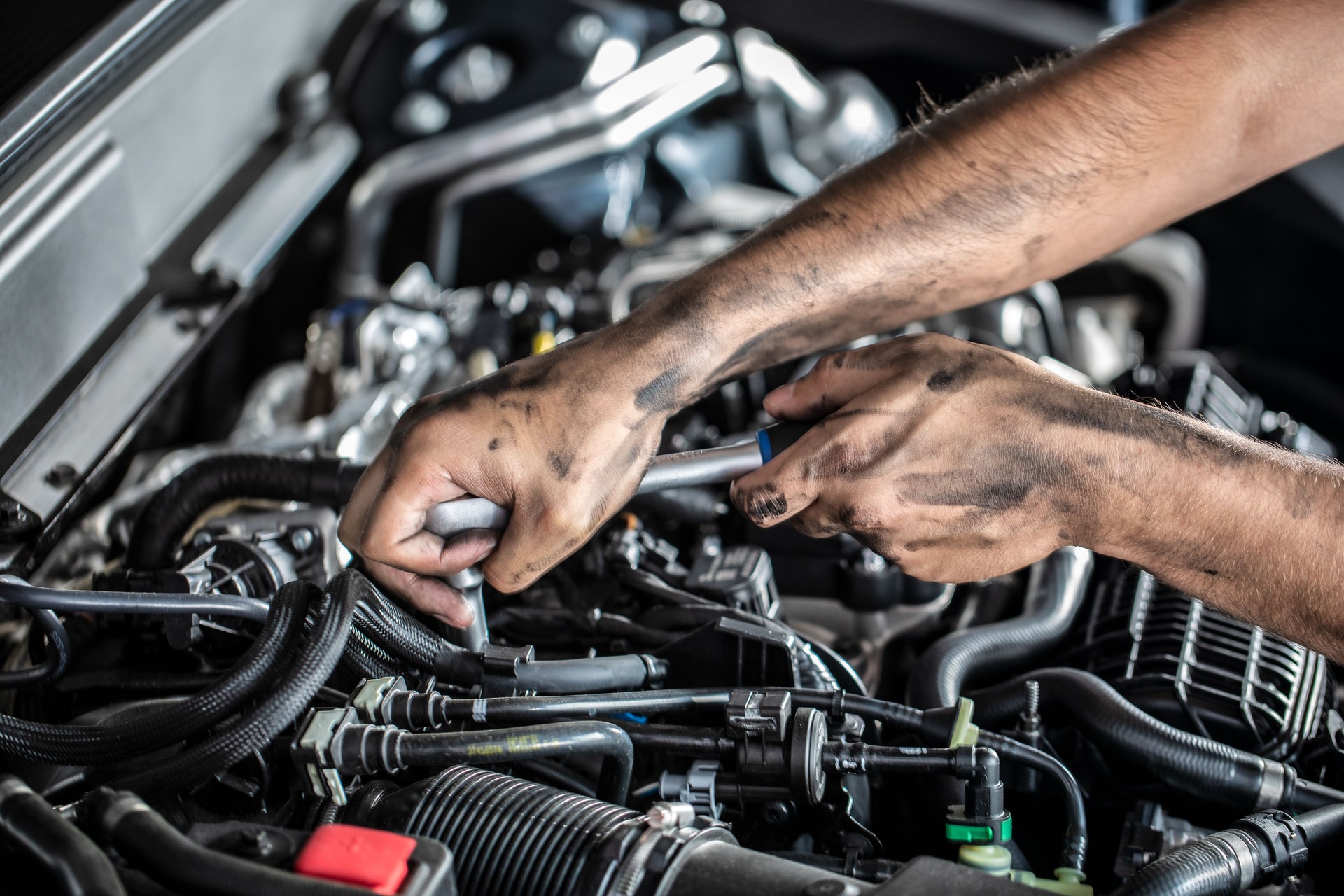 Auto mechanic working and repair on car engine in mechanics garage. Car service.